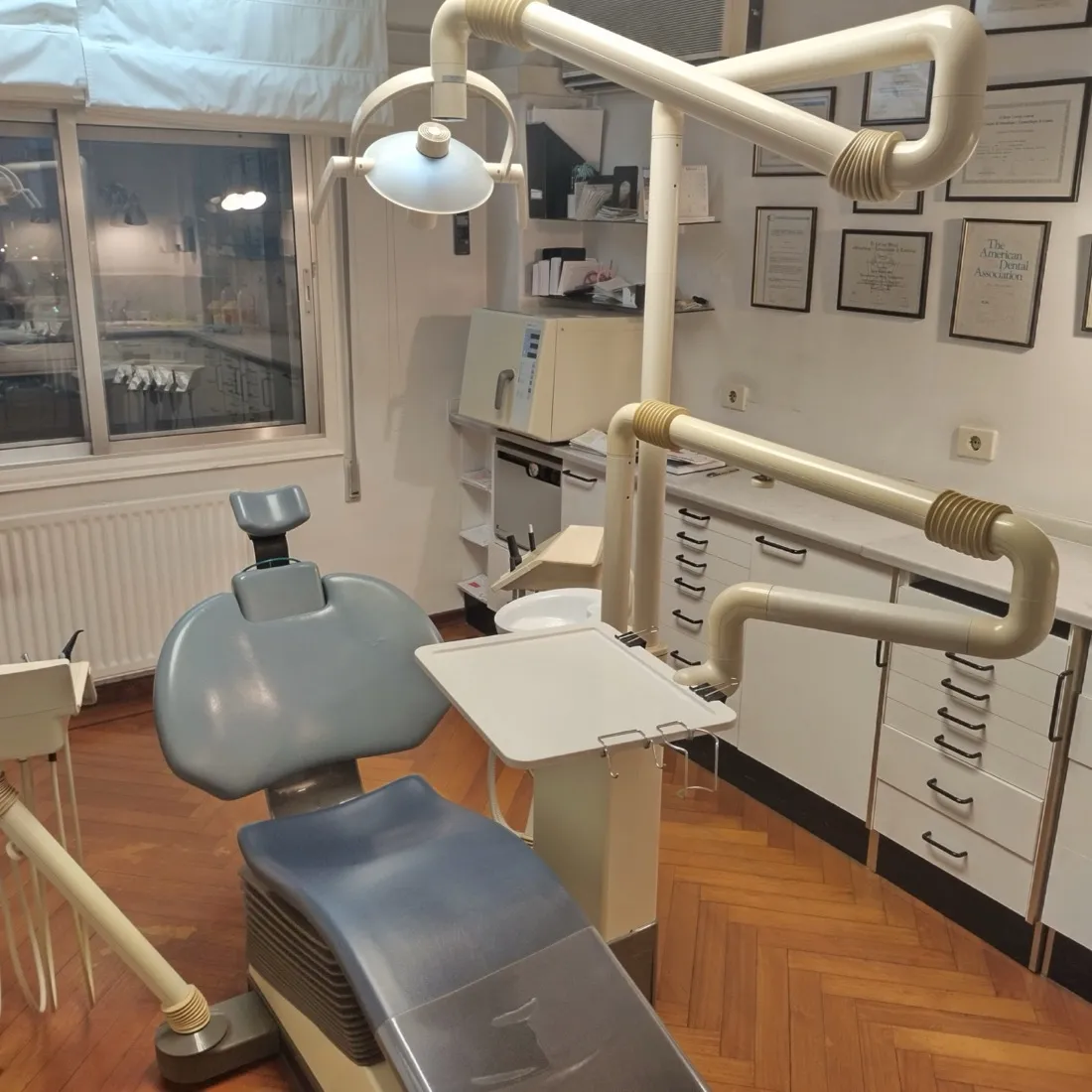 Gabinete de la Clínica Dental Cendón con sillón dental y pared de diplomas